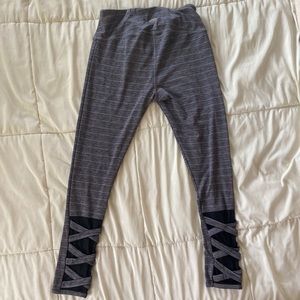 Grey striped leggings with criss-cross mesh detailing on back of leg